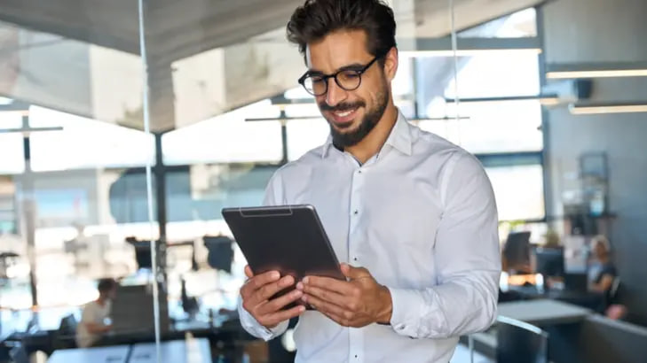مهندس أو مستشار يستخدم جهازاً لوحياً (Tablet) في موقع عمل.
